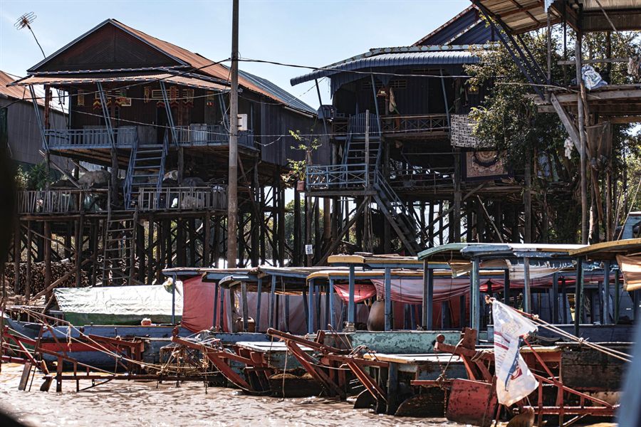 Tall wooden stilt houses and moored boats in Kampong Phluk village in the dry season